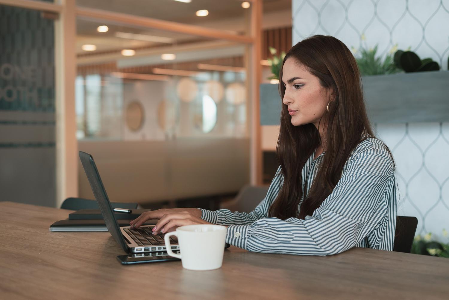 Mujer profesional trabajando con un ordenador portátil en una oficina moderna