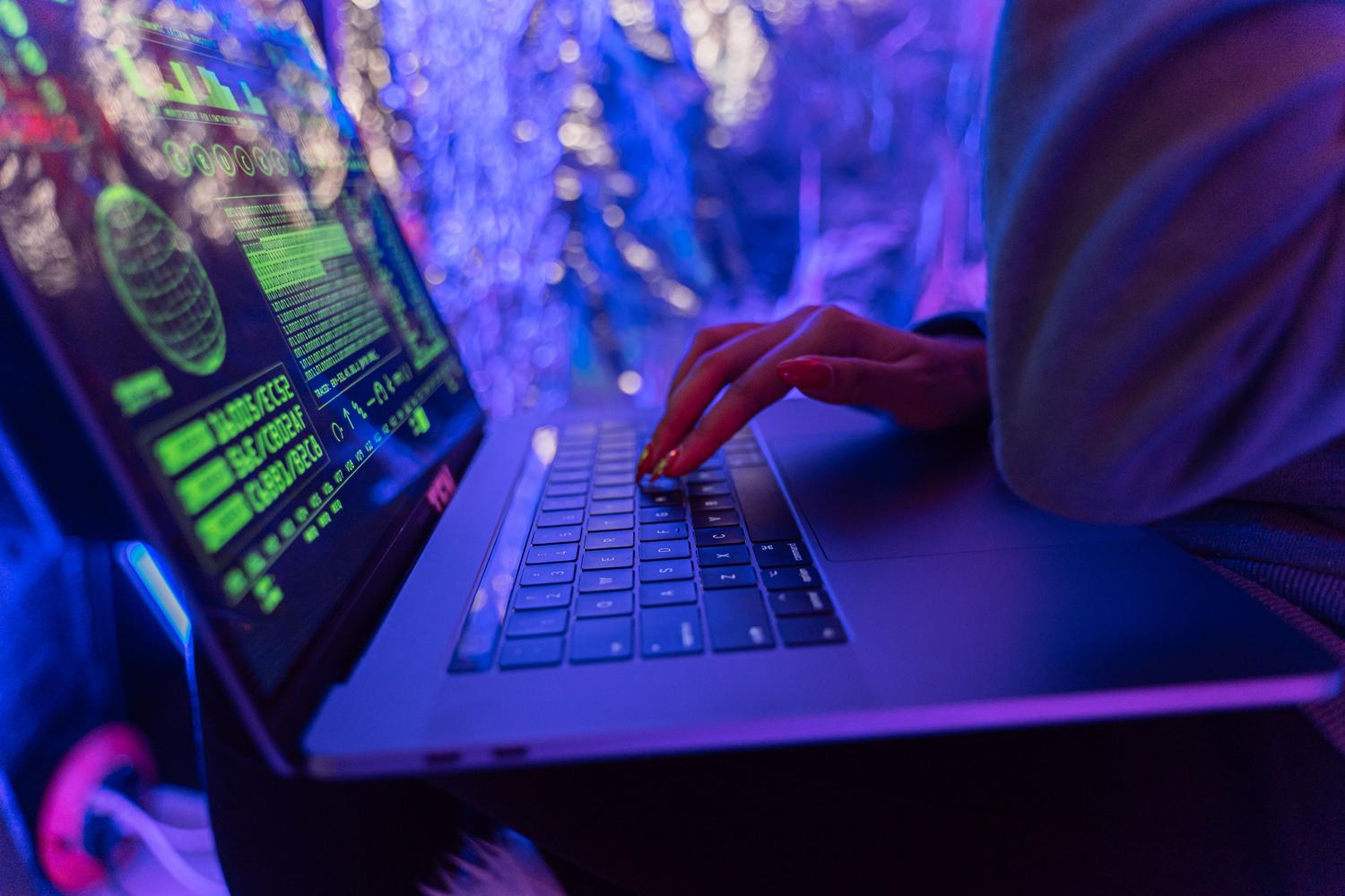 Entorno técnico de ciberseguridad con código en pantalla y luces neón