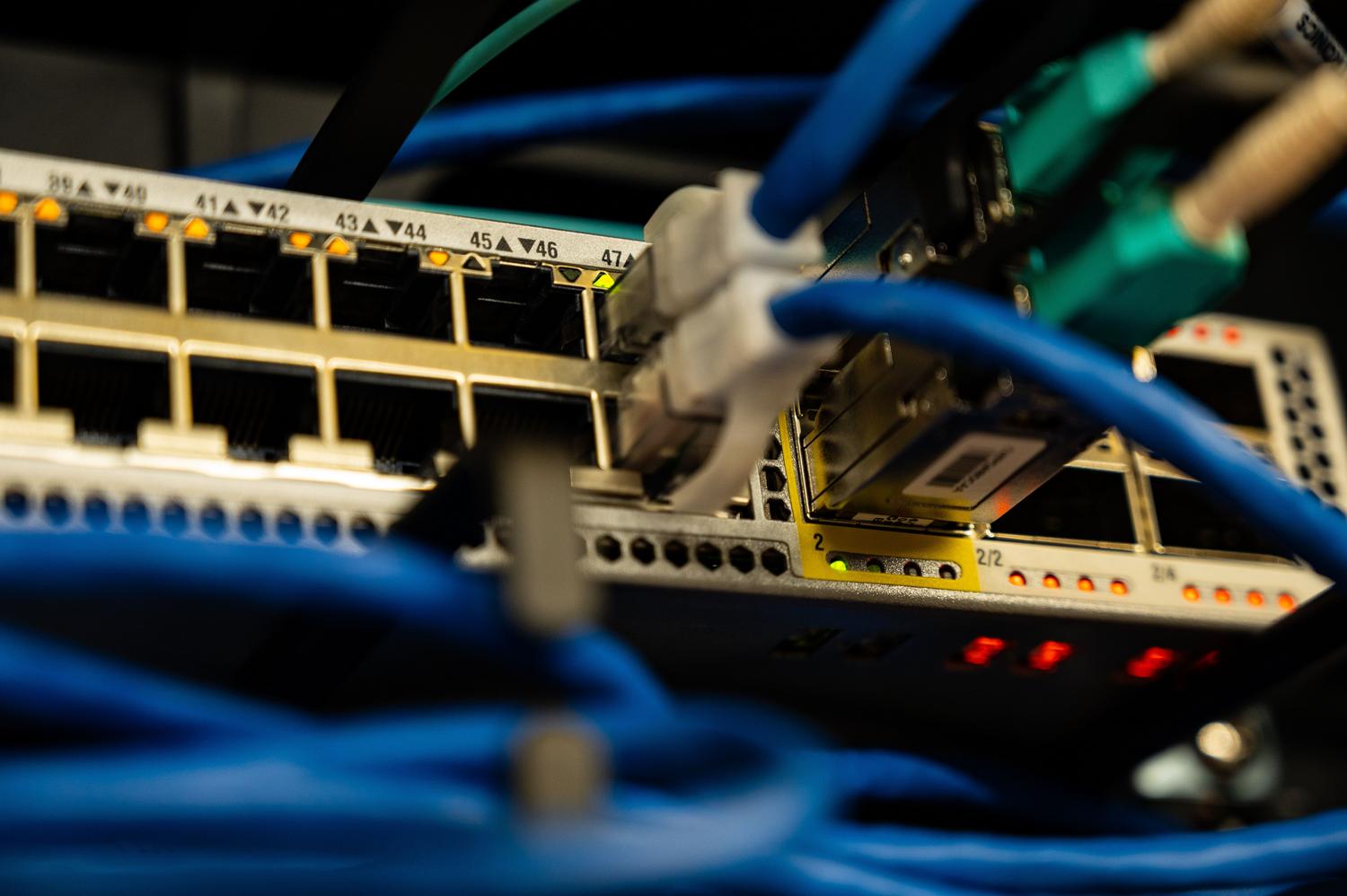 Detalle de cables Ethernet conectados a un switch de red, ilustrando la infraestructura de hardware de red.