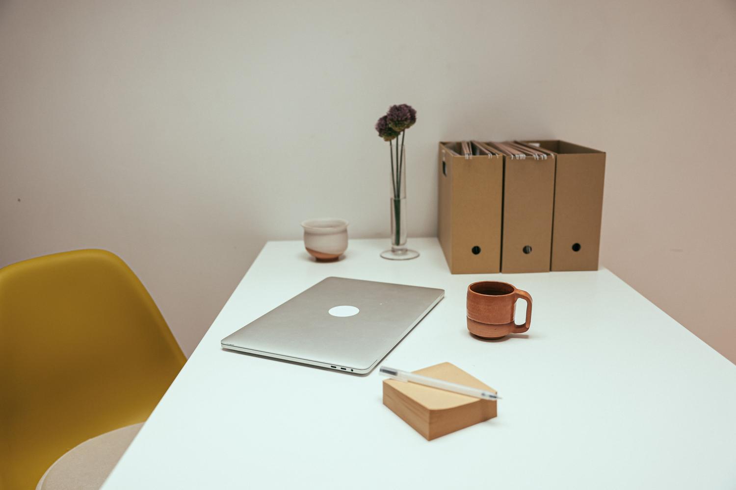 Escritorio de oficina limpio y ordenado con portátil y café, evocando la productividad y el orden digital tras renombrar archivos.
