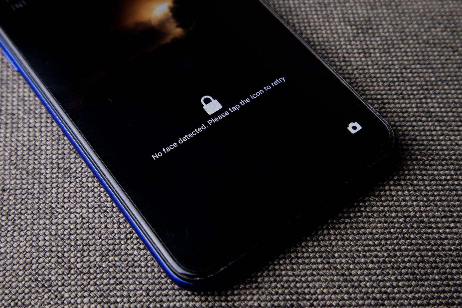 Pantalla de bloqueo de smartphone con mensaje de error de reconocimiento facial, ilustrando el acceso restringido.