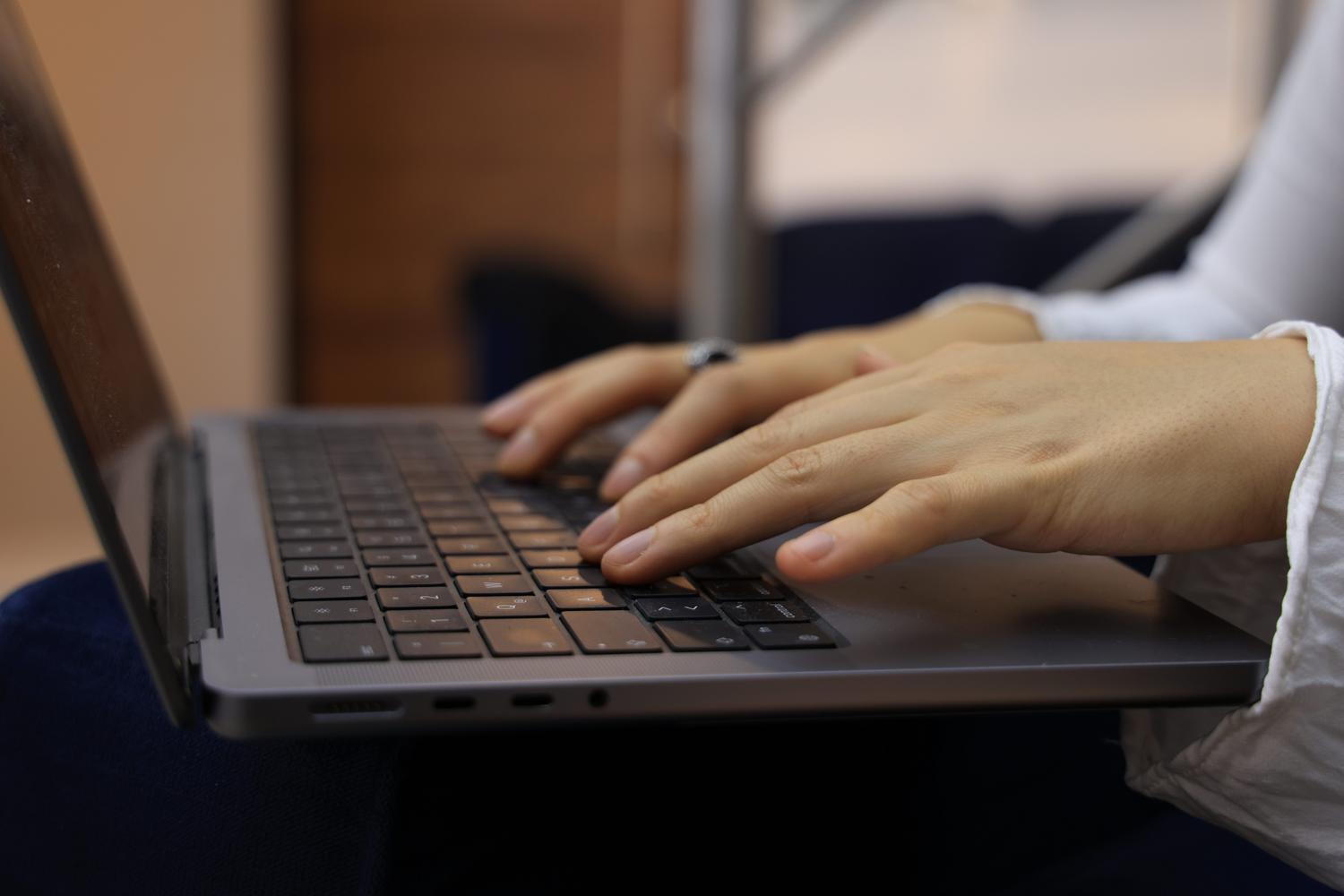 Primer plano de manos sobre el teclado de un portátil, ideal para ilustrar atajos de teclado como copiar y pegar.