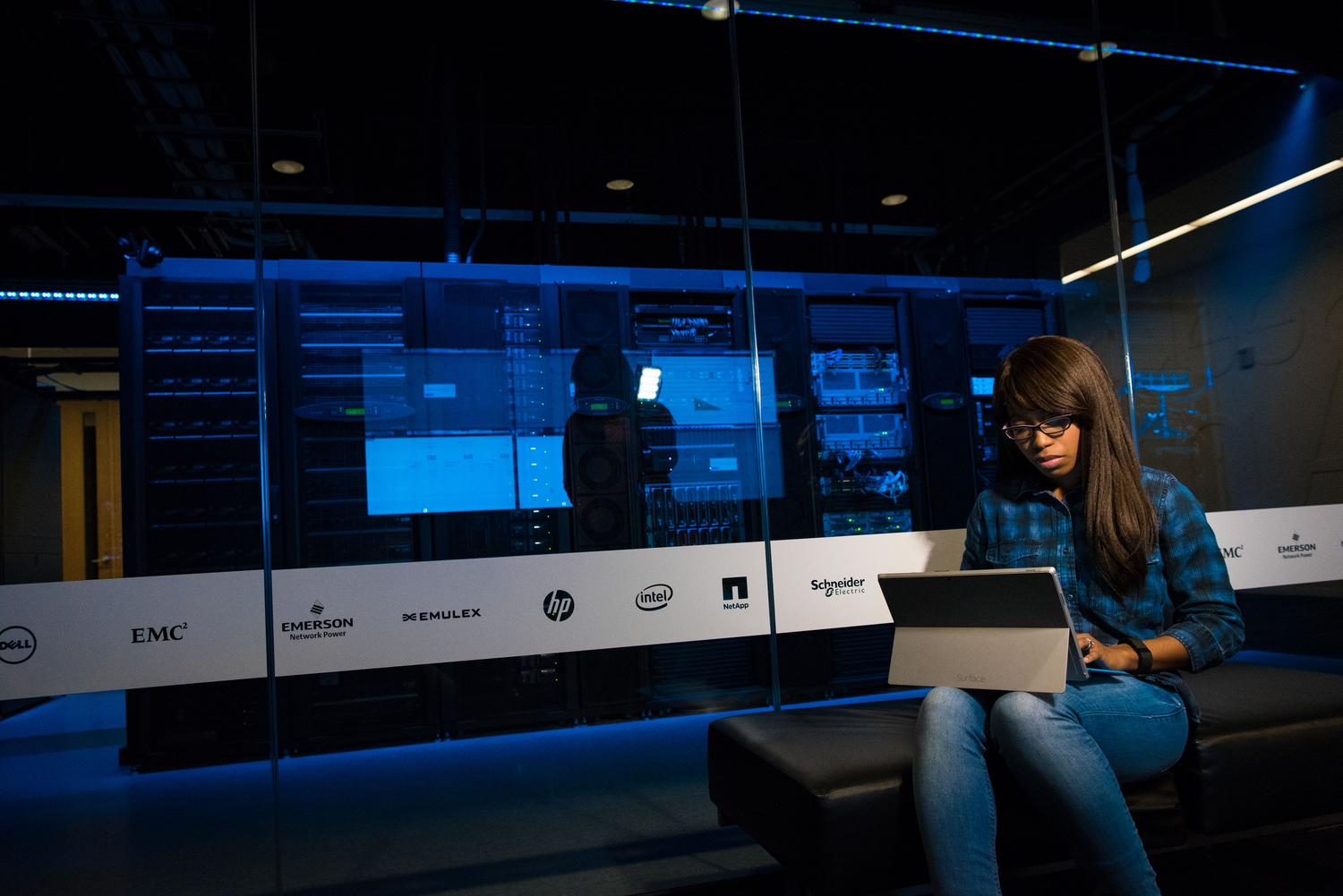 Profesional de IT trabajando con un ordenador portátil en un centro de datos moderno, simbolizando la gestión de la seguridad de la información.