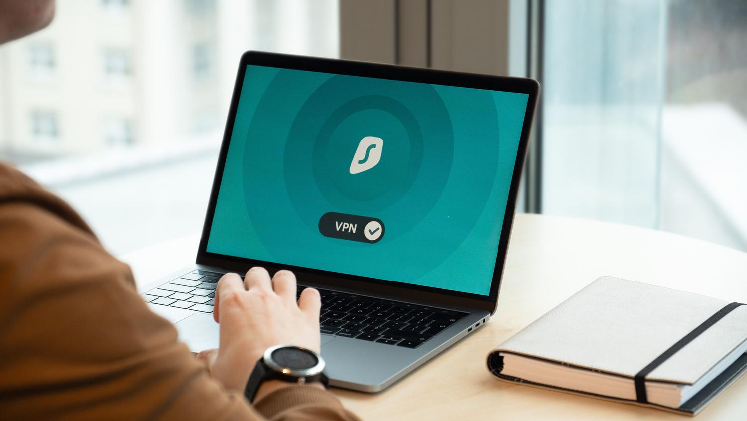 Persona en una oficina de pyme utilizando una conexión VPN segura en su portátil, ejemplificando la aplicación de medidas técnicas de seguridad.