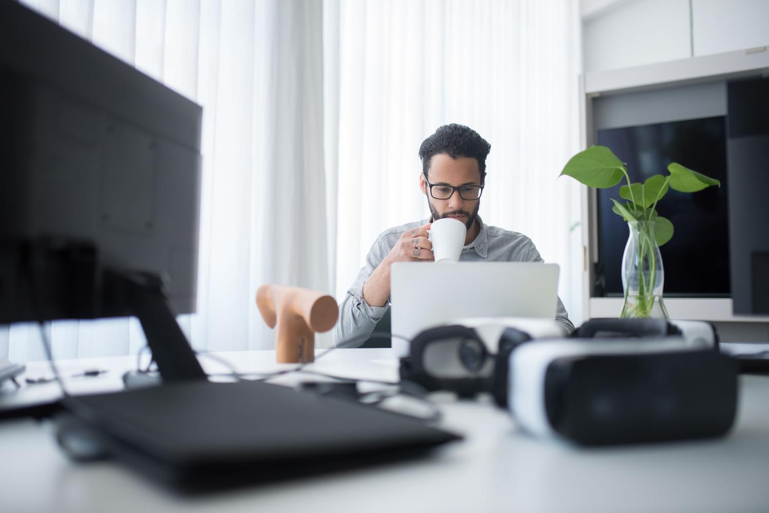 Hombre concentrado trabajando con tecnología avanzada en un espacio de trabajo contemporáneo, simbolizando la innovación y la productividad asistida por IA.