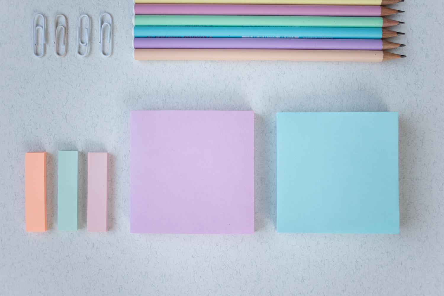 Composición plana de papelería en tonos pastel con notas adhesivas, ideal para ilustrar la personalización de colores en las notas.