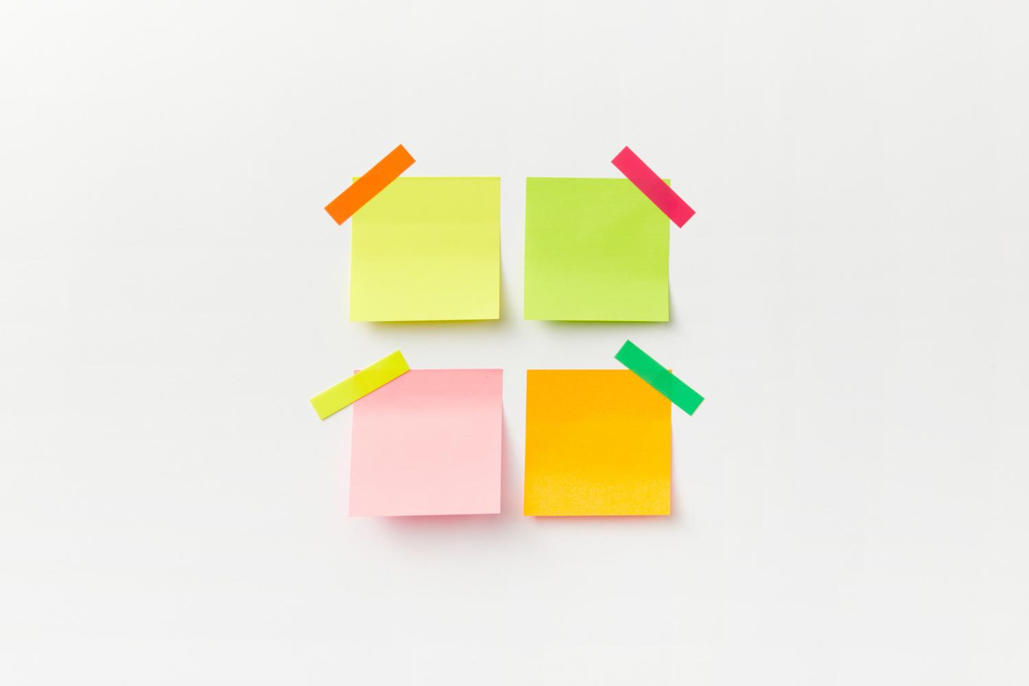 Cuatro notas adhesivas de colores vibrantes sobre un fondo blanco, simbolizando la organización de ideas por categorías.