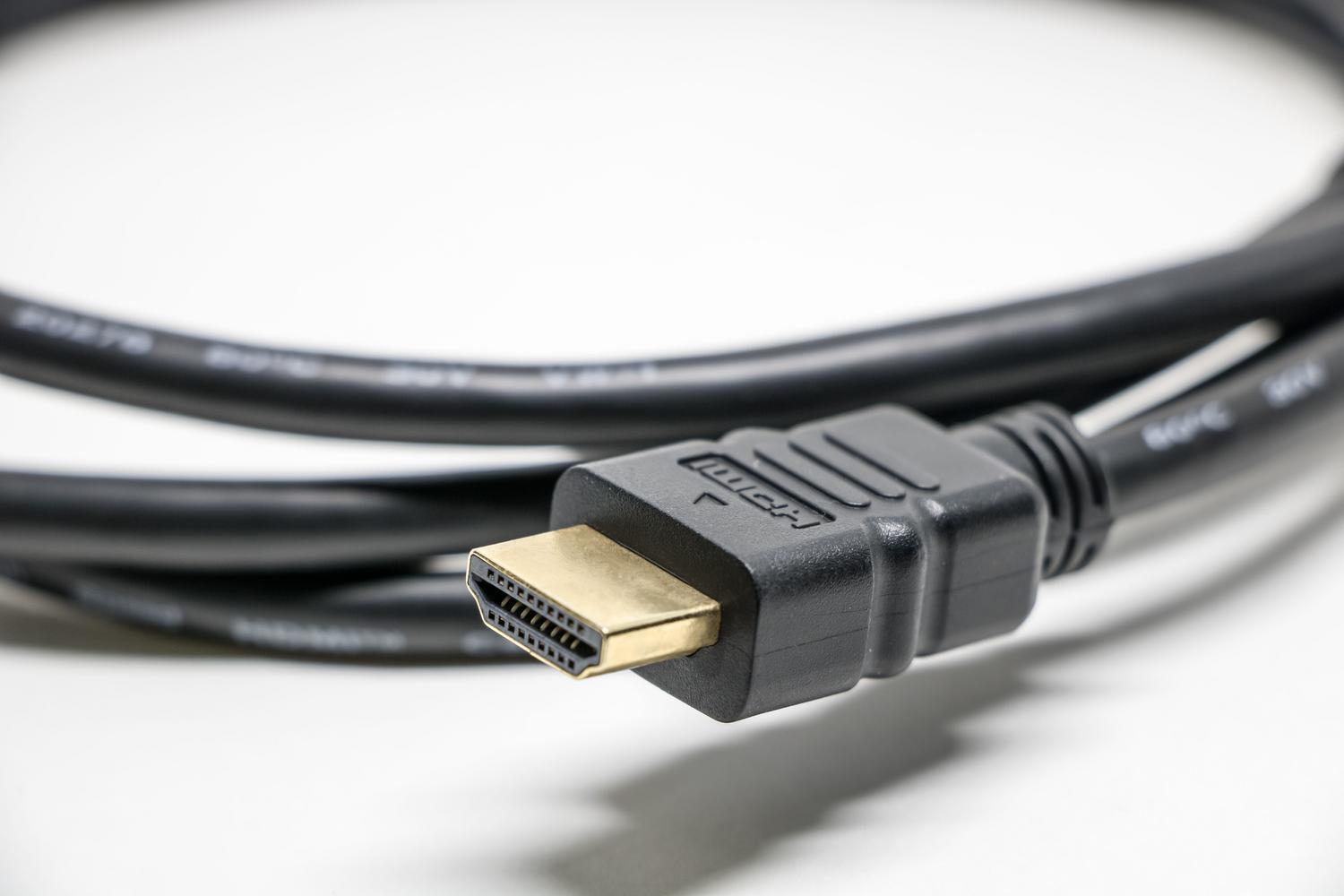 Primer plano de un cable HDMI de alta calidad con conectores dorados, ideal para probar la sustitución del cable.