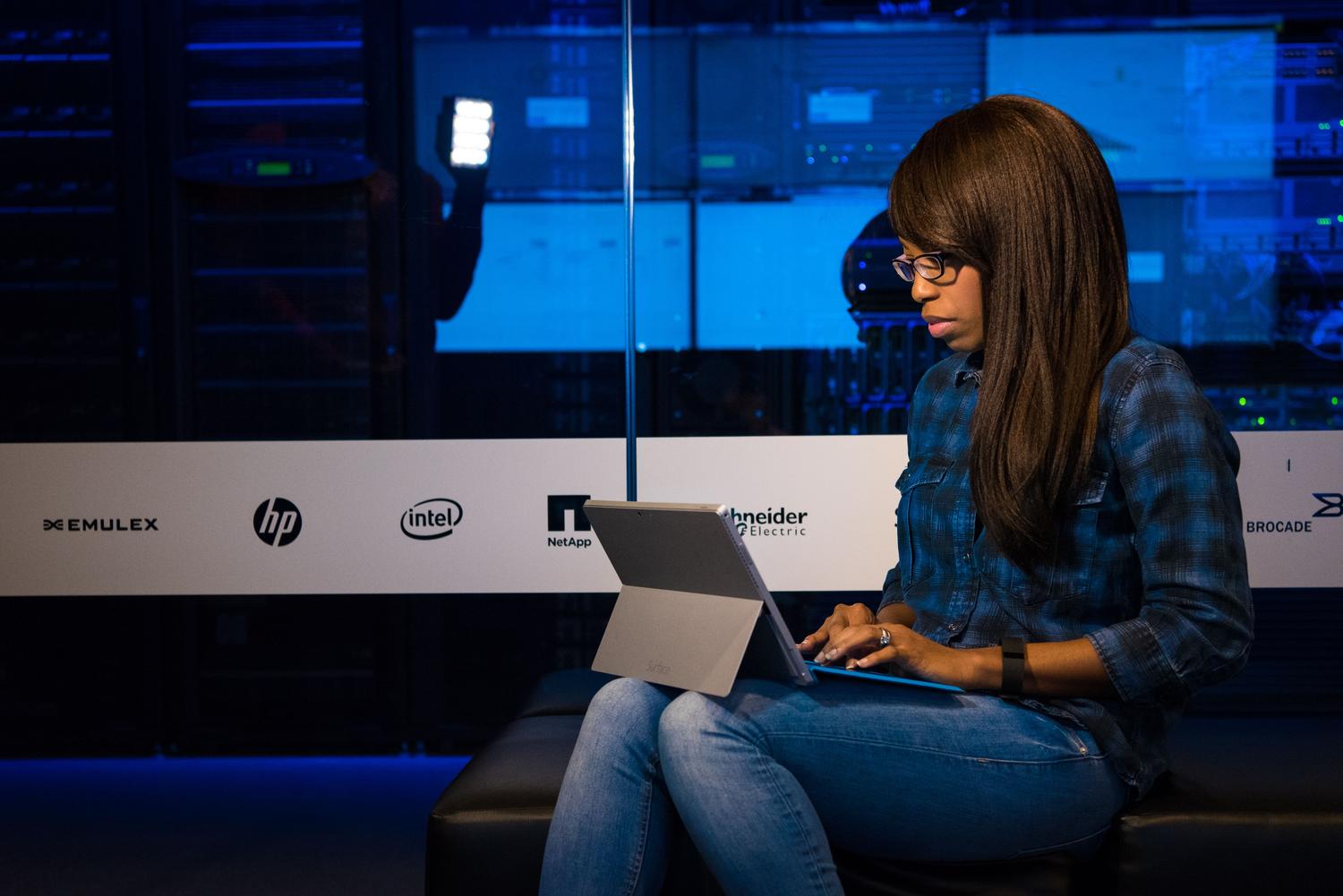 Profesional de IT trabajando en una sala de servidores, ilustrando la parte de supervisión y gestión de los entornos de IA.