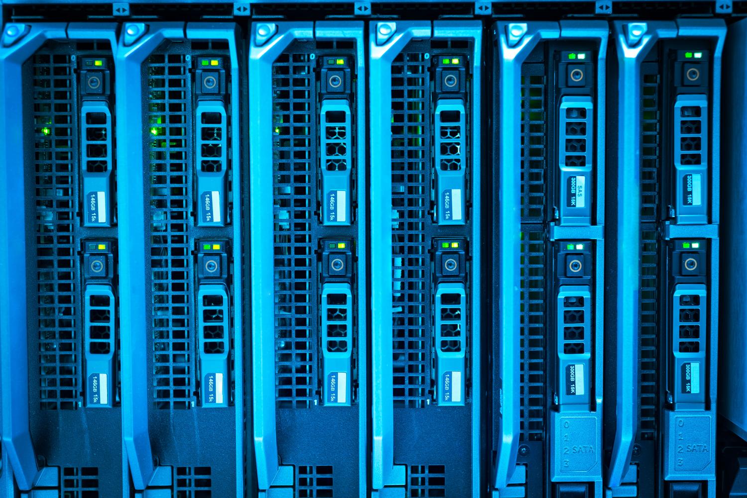 Racks de servidores iluminados en un centro de datos, representando la infraestructura técnica de los PCs virtuales en la nube.