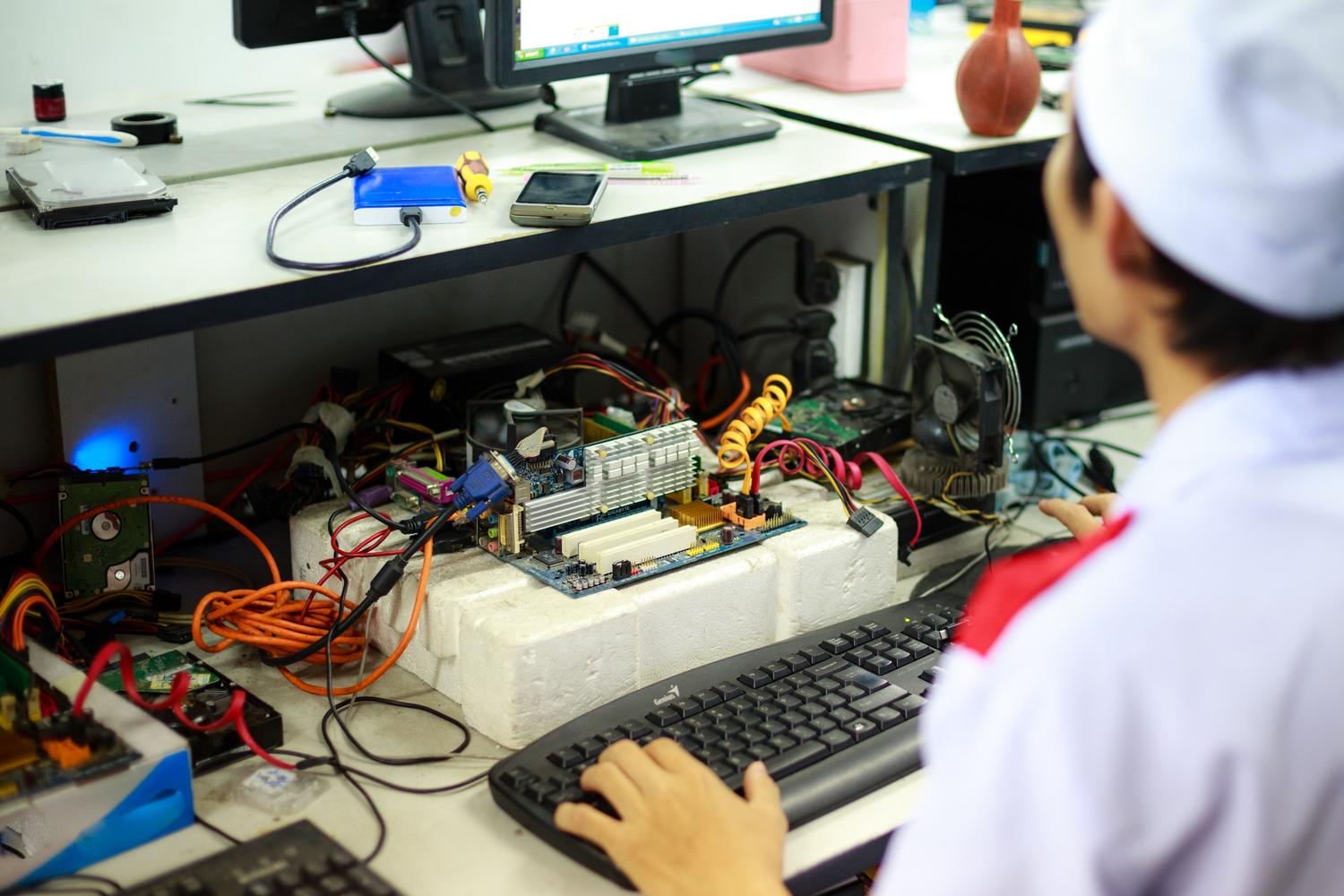 Técnico informático trabajando en la reparación de componentes internos de un ordenador.