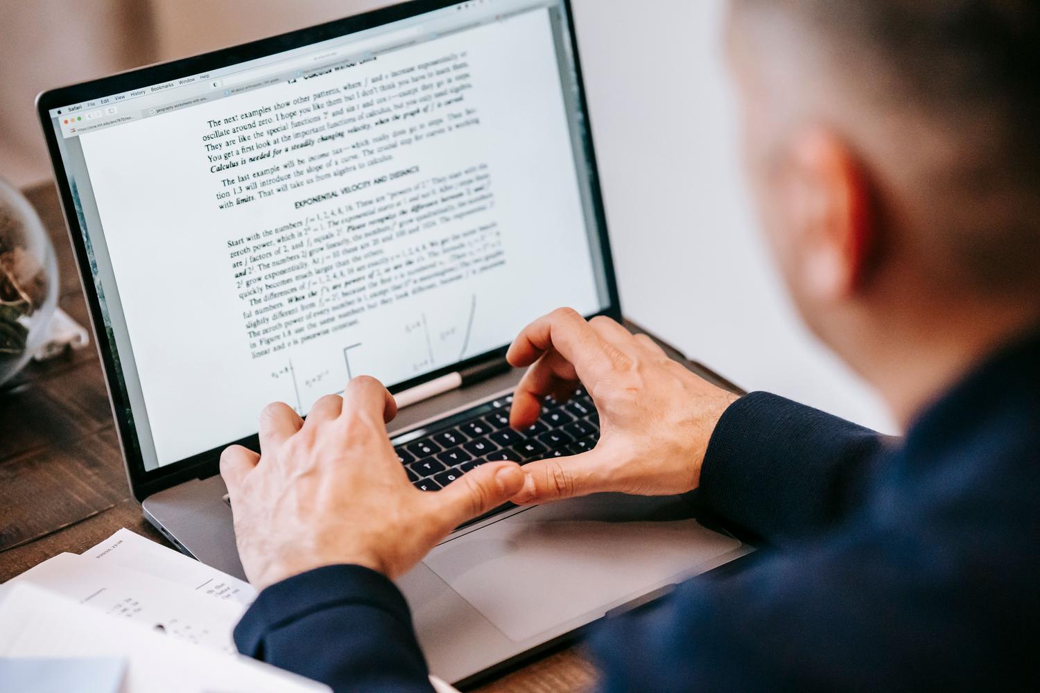 Hombre concentrado escribiendo en su portátil en un entorno de oficina en casa, ilustrando la facilidad de uso de las herramientas de conversión.