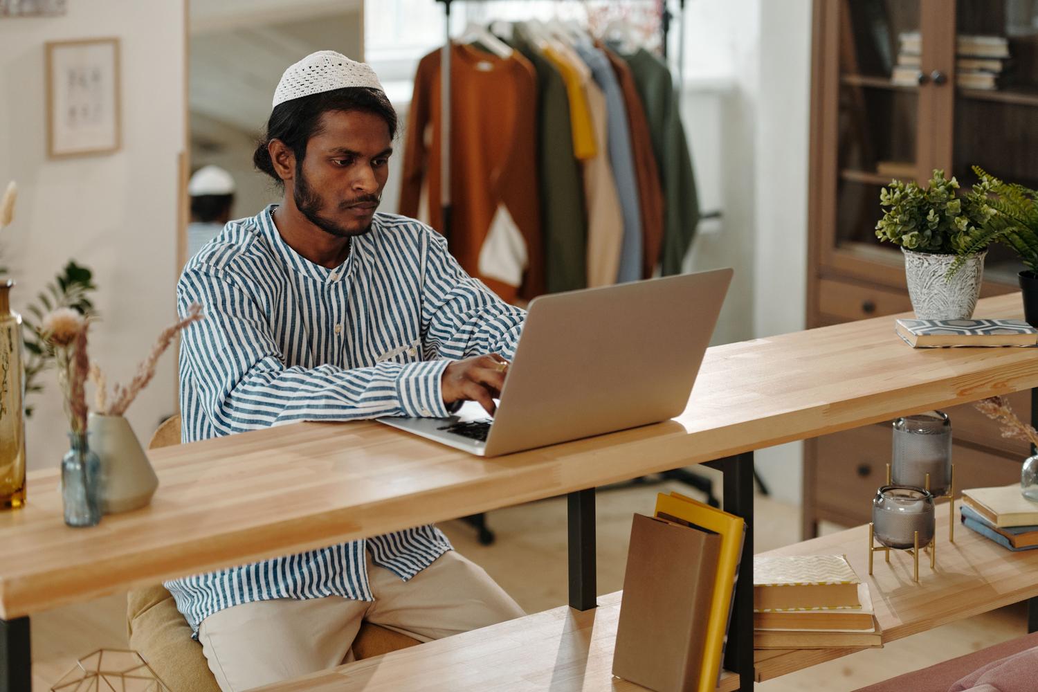 Una persona trabajando con un ordenador portátil en un entorno doméstico moderno, sugiriendo el uso personal y profesional de OneDrive.