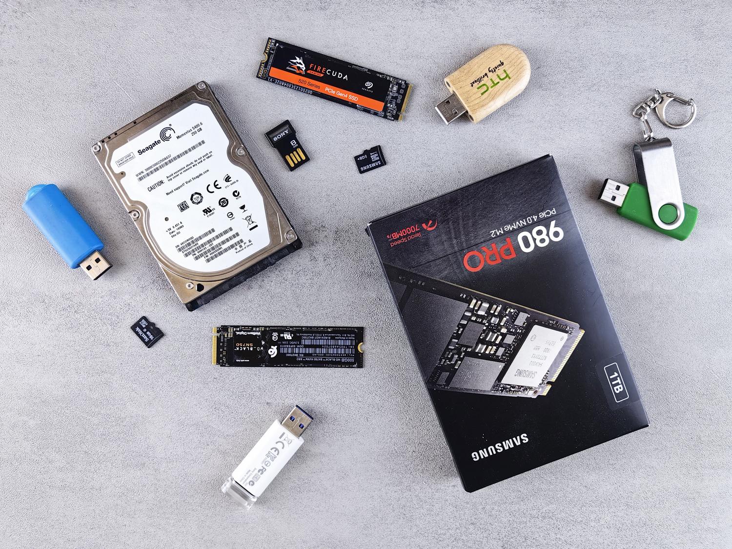 Variedad de dispositivos de almacenamiento digital como pendrives y discos SSD sobre un escritorio. Variedad de dispositivos de almacenamiento digital como pendrives y discos SSD sobre un escritorio.