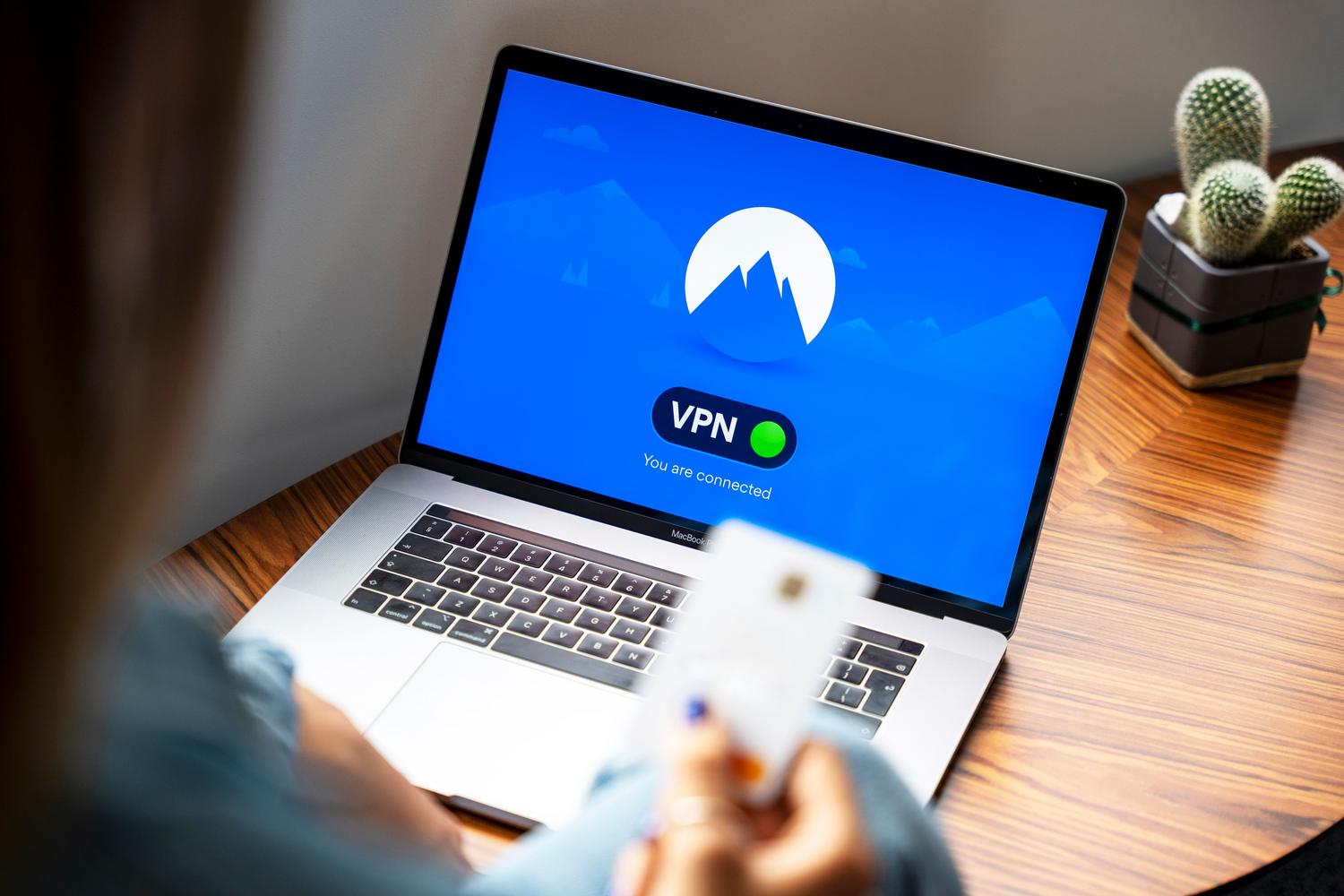 Persona utilizando un ordenador portátil en un entorno moderno, representando la navegación segura y el uso de servicios de VPN.