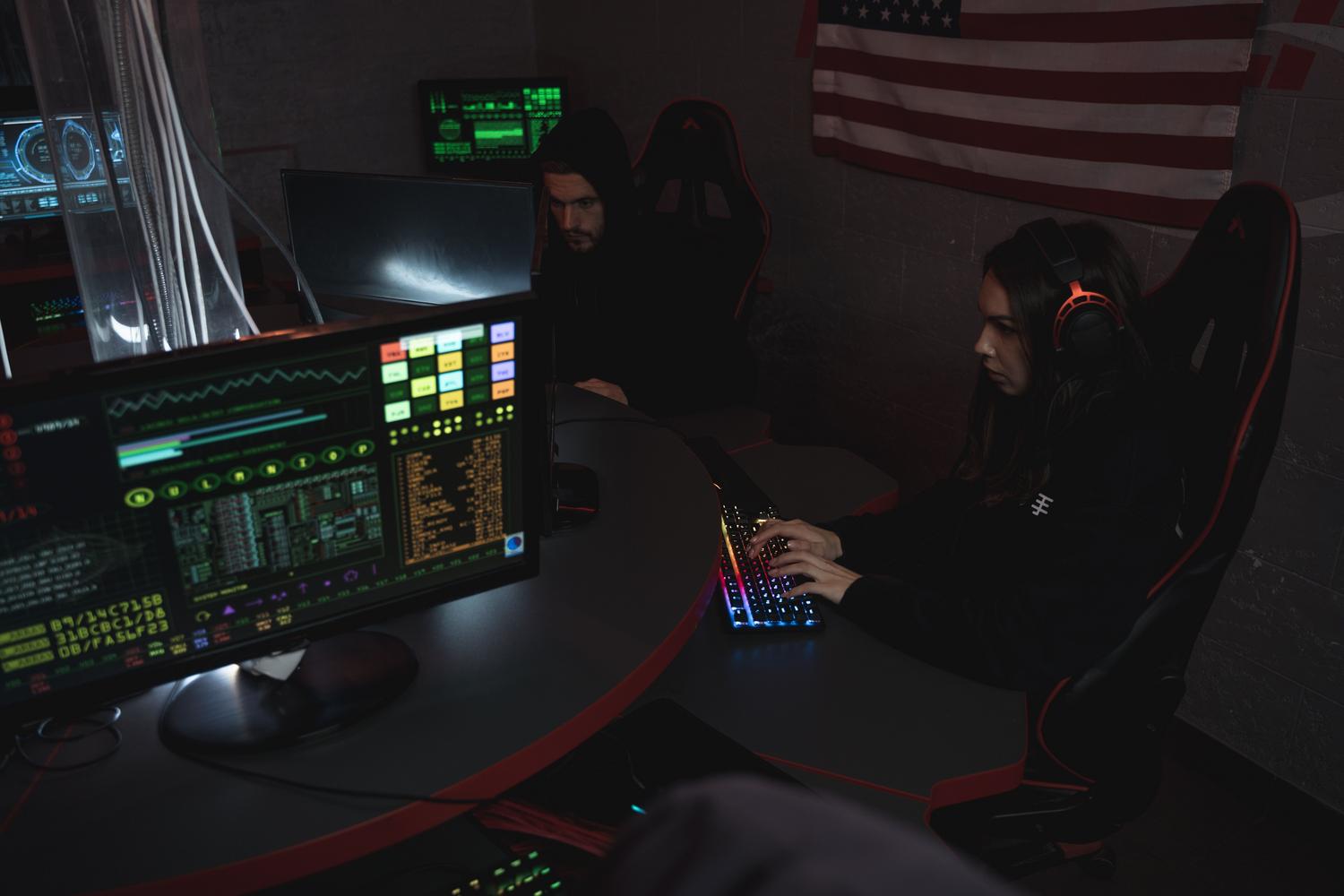 Equipo de profesionales de seguridad colaborando en un centro de operaciones de seguridad (SOC) con múltiples monitores y códigos.