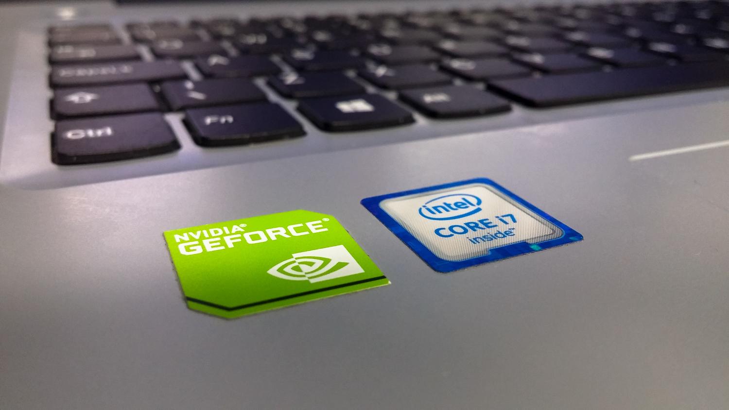 Etiquetas de componentes de hardware Intel y NVIDIA en el chasis de un portátil, ilustrando la búsqueda física del número de serie