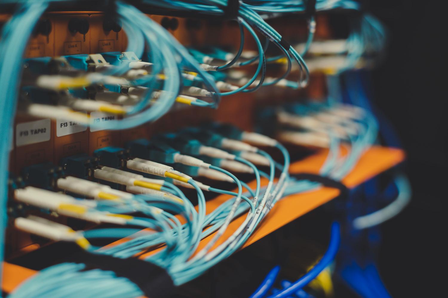 Primer plano de cables de red interconectados en un switch, simbolizando los eslabones de conexión y la latencia.