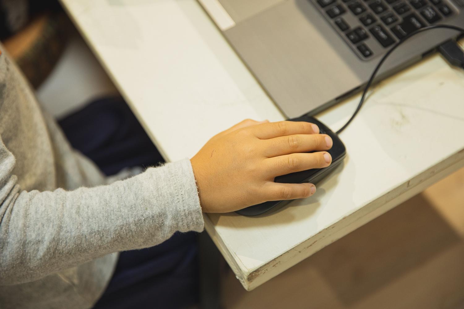 Estudiante utilizando un ordenador portátil en un aula escolar, reflejando el uso de la tecnología en el entorno educativo y la necesidad de su regulación.