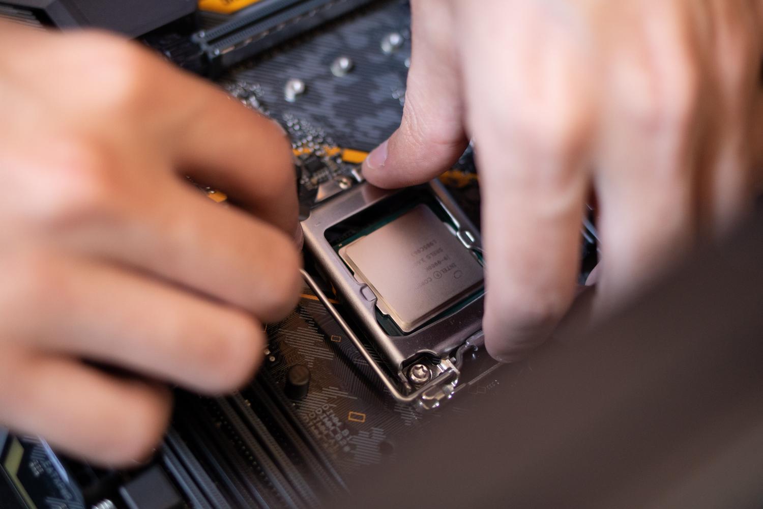 Manos de un técnico instalando un procesador en una placa base, representando la optimización y diagnóstico de hardware.