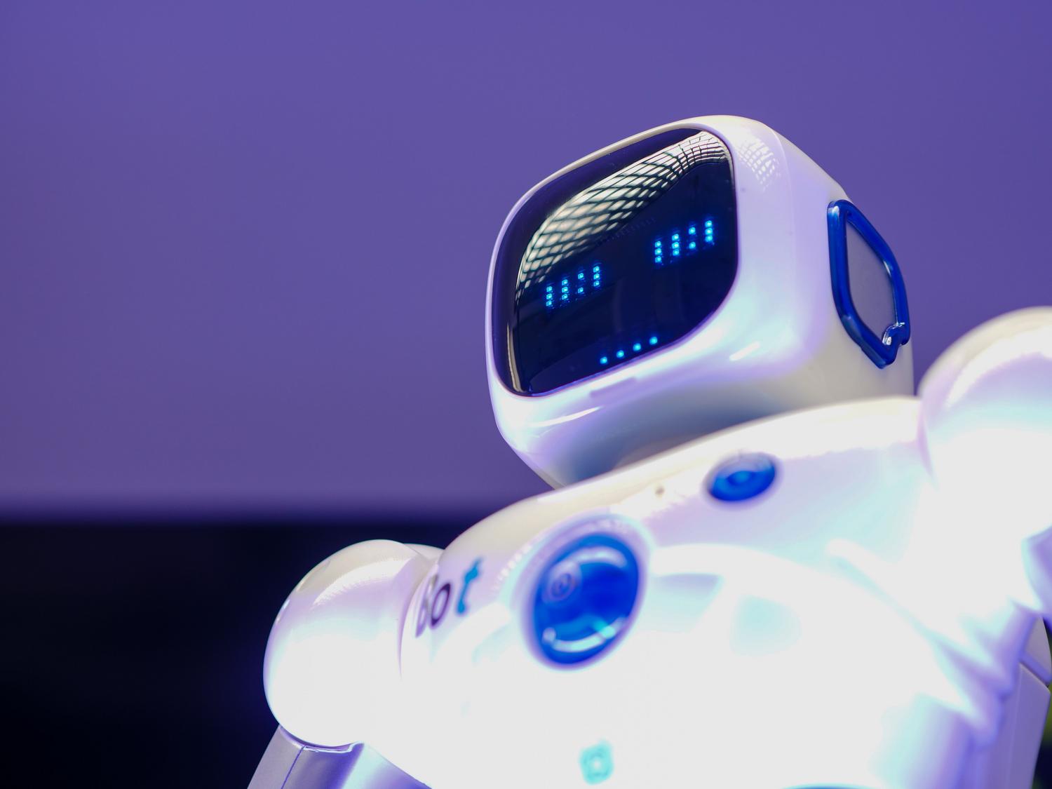 Primer plano de un robot humanoide con pantalla digital en el rostro, simbolizando la inteligencia artificial general y los dilemas existenciales.