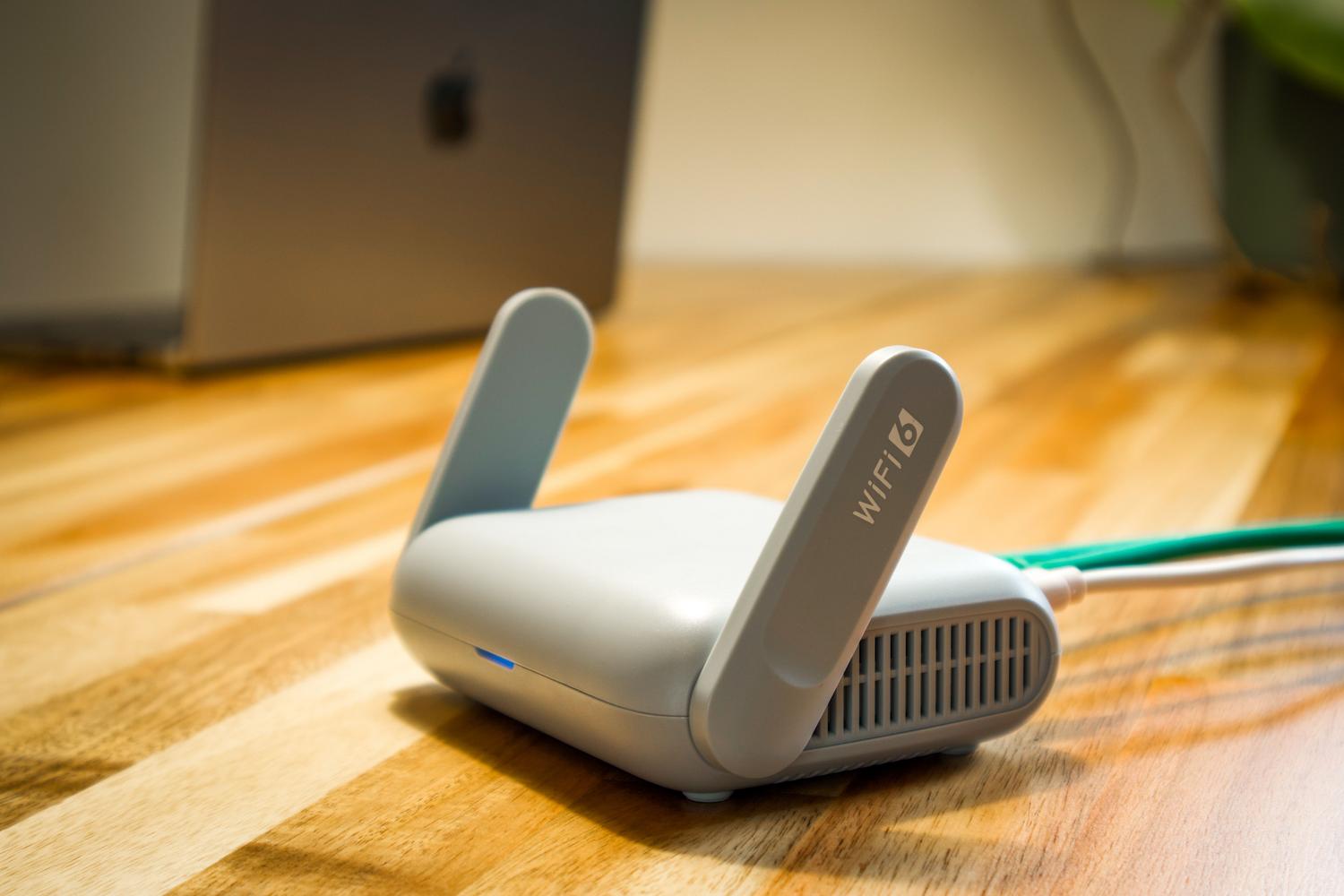 Router WiFi 6 moderno sobre un escritorio de madera, ilustrando la conectividad de red inalámbrica.