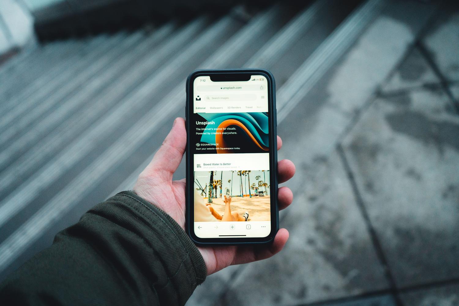 Persona navegando por una página web en su smartphone en un entorno cotidiano.