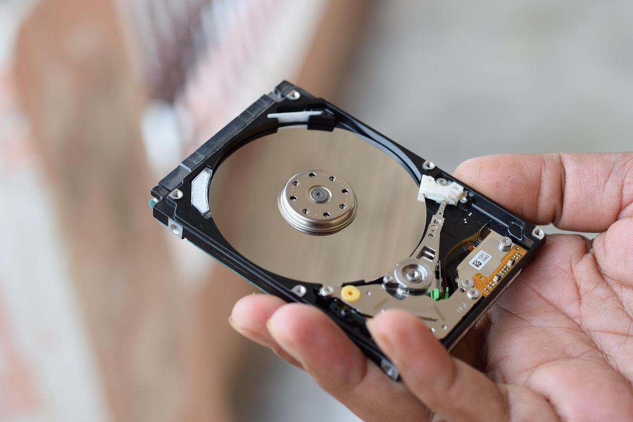 Imagen técnica de un disco duro interno abierto, representando el almacenamiento de datos y la gestión de espacio en disco.